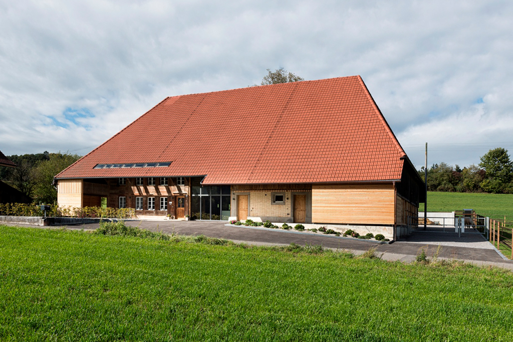 Umgebautes Bauernhaus in der Region Buechibärg (Bucheggberg) welches von der Kobi Architektur AG renoviert wurde und mit einer hellen Holzfassade und einer grossen Dachfläche mit neuen Ziegeln glänzt.